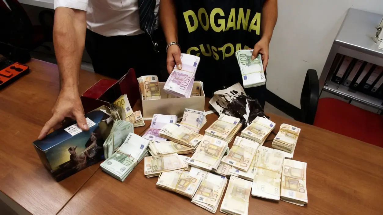 Personale doganale controlla grandi quantità di banconote euro su un tavolo