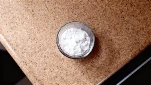 Ciotola di vetro con bicarbonato di sodio su un piano di lavoro