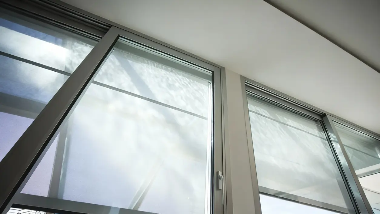 Finestre moderne con tende a rullo che filtrano la luce solare