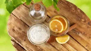 Ingredienti naturali come limone, bicarbonato e aceto su un tavolo di legno