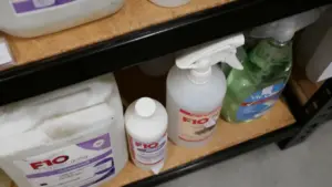 Vari bottiglie di disinfettanti su uno scaffale in un ambiente interno.