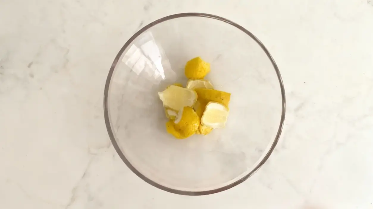 Scorze di agrumi in una ciotola di vetro su un piano chiaro